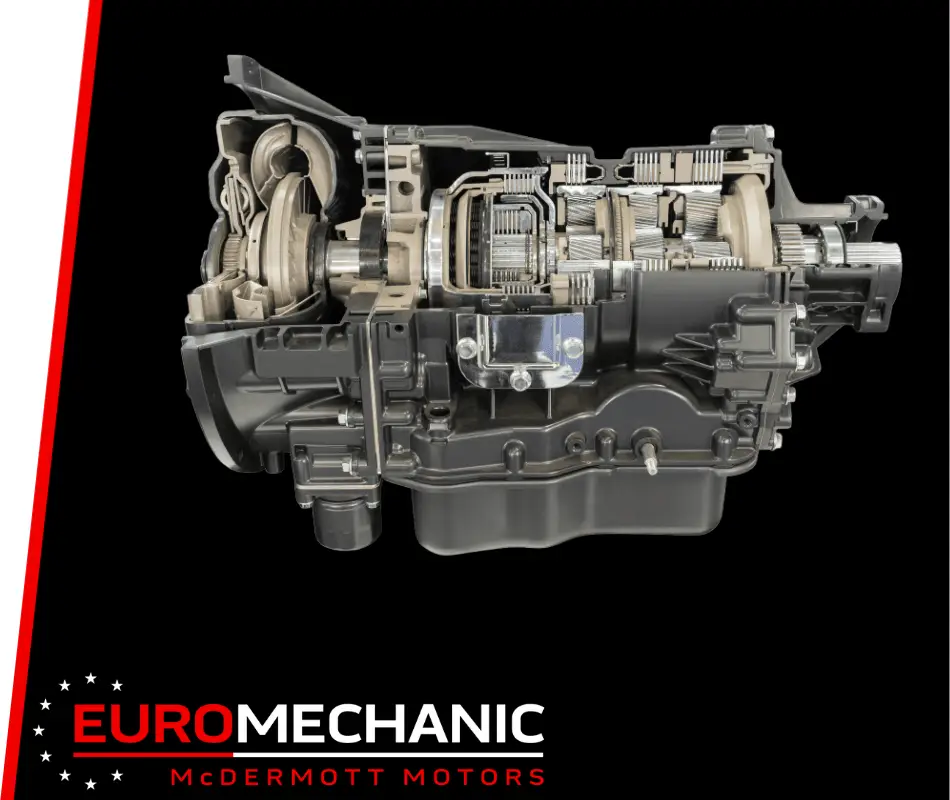 Cutaway view of a car transmission system, highlighting its intricate gears and components on a black background. The image subtly emphasizes the expertise in transmission repair, featuring the EuroMechanic and McDermott Motors logos at the bottom. Euro Mechanic | Brock Road Garage Guelph | Top Reviewed Auto Repair Shop in Guelph | Visit brockroadgarage.ca