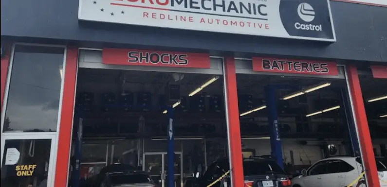 Auto repair shop with EUROMECHANIC and Redline Automotive signage located by Brock Road Garage. The front features sections for Shocks and Batteries. Several cars are visible inside, and a door marked with a Staff Only sign adds an exclusive touch to the bustling space. Euro Mechanic | Brock Road Garage Guelph | Top Reviewed Auto Repair Shop in Guelph | Visit brockroadgarage.ca