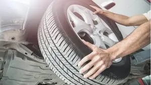 Mechanic examining uneven tire wear before winter tire installation in Guelph